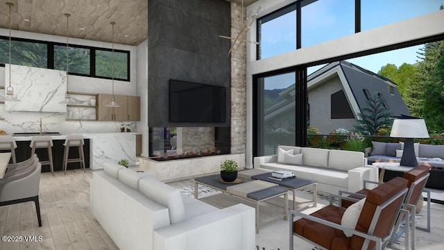 living area featuring a multi sided fireplace, a towering ceiling, and light wood finished floors