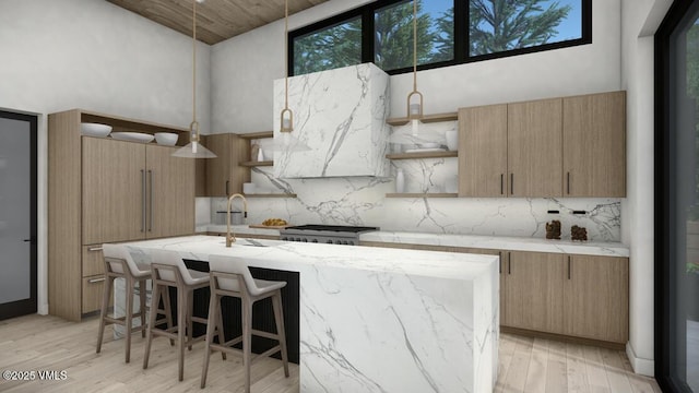 kitchen featuring light wood finished floors, tasteful backsplash, a towering ceiling, a kitchen island with sink, and open shelves