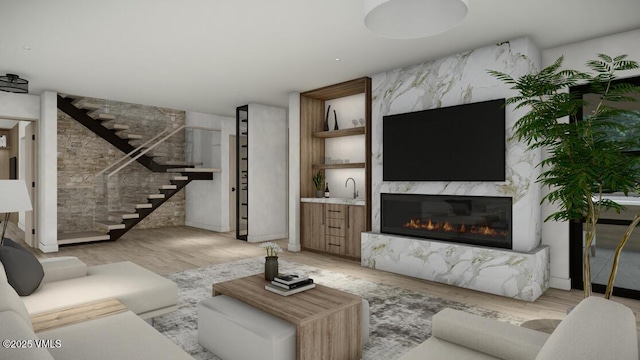 living room featuring stairway, a fireplace, and light wood-style flooring