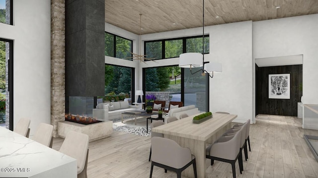 dining space with a high ceiling, wood-type flooring, and a wealth of natural light