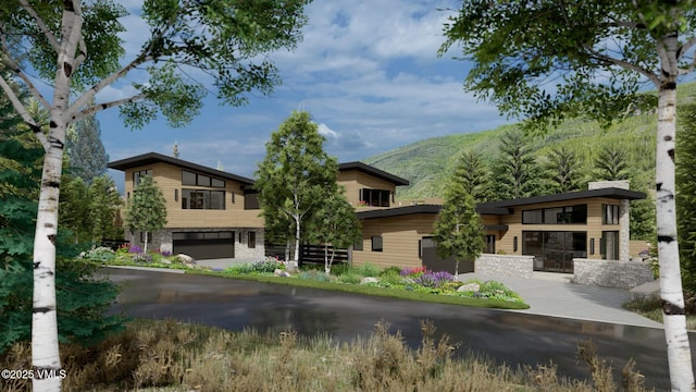 view of front of house featuring a garage, driveway, and a mountain view