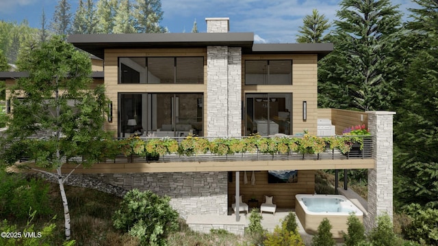 rear view of property featuring stone siding, a chimney, an outdoor hot tub, and a balcony