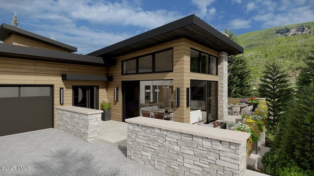 view of front of property with an outdoor hangout area, a patio, and a garage