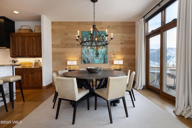 751 Singletree Rd Unit 28, Edwards, CO 81632 - dining space featuring a chandelier, light wood-type flooring, and wooden walls