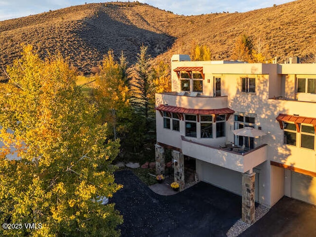 751 Singletree Rd Unit 28, Edwards, CO 81632 - back of house with stucco siding, a mountain view, and an attached garage