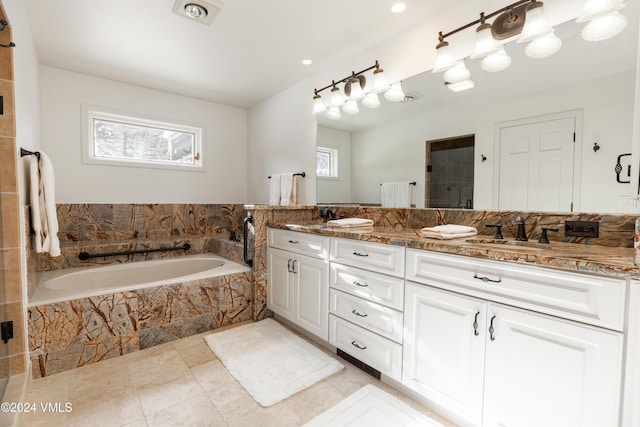 bathroom with vanity and shower with separate bathtub