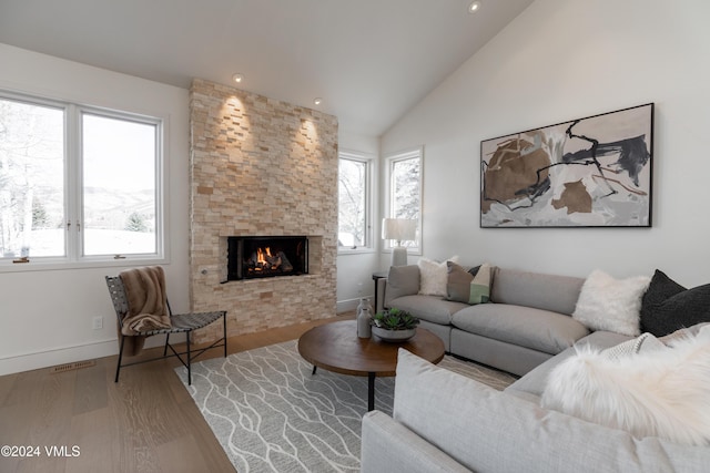 living room with lofted ceiling, hardwood / wood-style flooring, and a fireplace