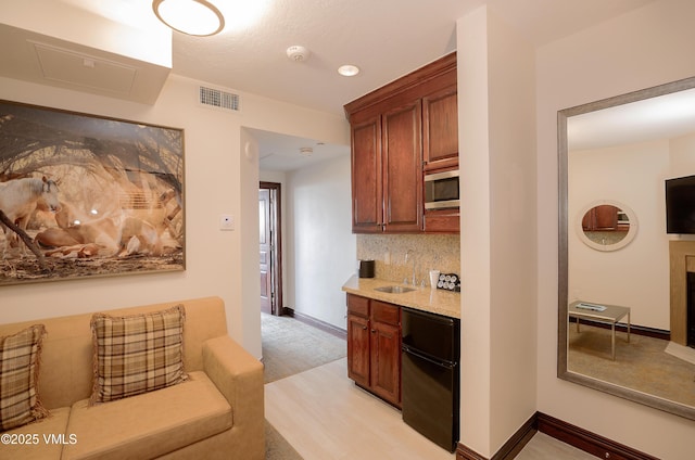 26 Avondale Ln Unit 409-H, Beaver Creek, CO 81620 - kitchen with stainless steel microwave, refrigerator, decorative backsplash, light stone countertops, and baseboards