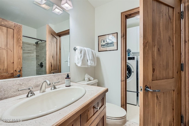 bathroom featuring vanity, washer / dryer, a shower, and toilet