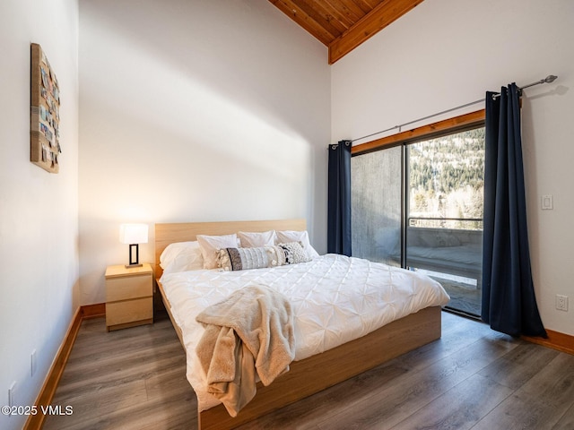 bedroom featuring access to outside, baseboards, and wood finished floors