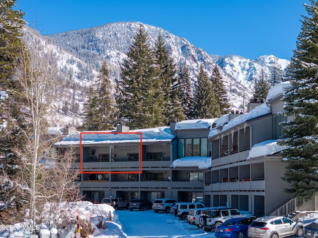 snow covered building featuring a mountain view