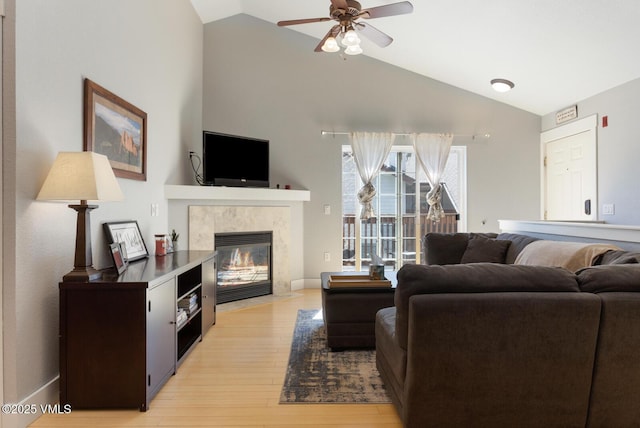 1303 Crazy Horse Cir Unit 1303, Edwards, CO 81632 - living area featuring light wood-style flooring, a ceiling fan, a high end fireplace, high vaulted ceiling, and baseboards