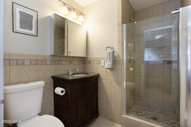1303 Crazy Horse Cir Unit 1303, Edwards, CO 81632 - bathroom featuring toilet, a shower stall, tile walls, vanity, and a wainscoted wall