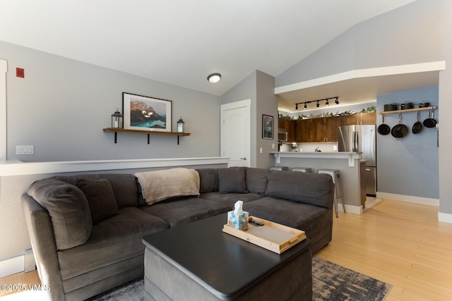 1303 Crazy Horse Cir Unit 1303, Edwards, CO 81632 - living room with light wood-style flooring, vaulted ceiling, and baseboards