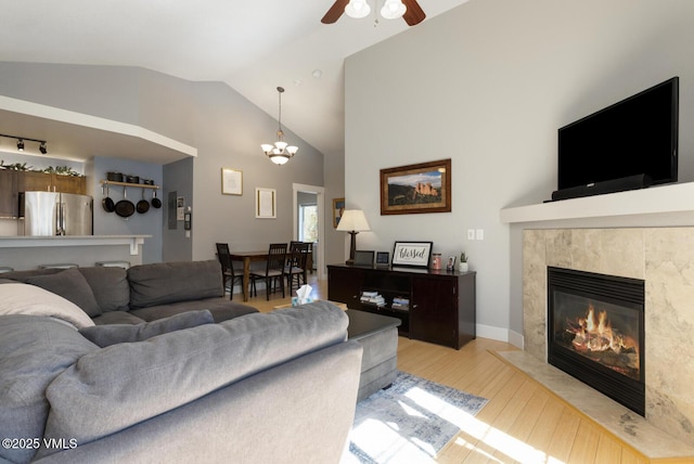 1303 Crazy Horse Cir Unit 1303, Edwards, CO 81632 - living area with wood finished floors, a ceiling fan, vaulted ceiling, a premium fireplace, and a chandelier