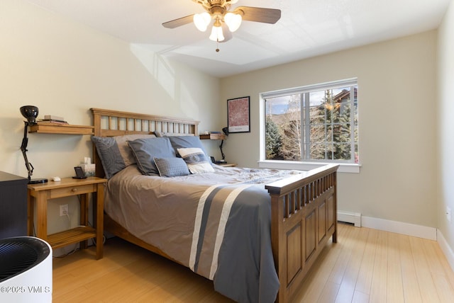 1303 Crazy Horse Cir Unit 1303, Edwards, CO 81632 - bedroom featuring baseboard heating, light wood-type flooring, baseboards, and a ceiling fan