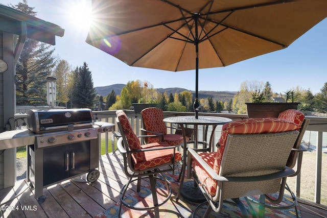 deck with a mountain view and area for grilling