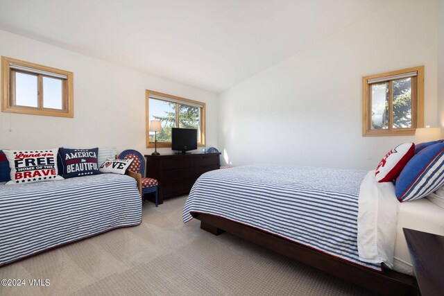 bedroom featuring lofted ceiling and light colored carpet