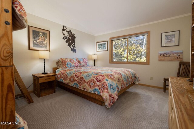 bedroom with crown molding, lofted ceiling, and light carpet