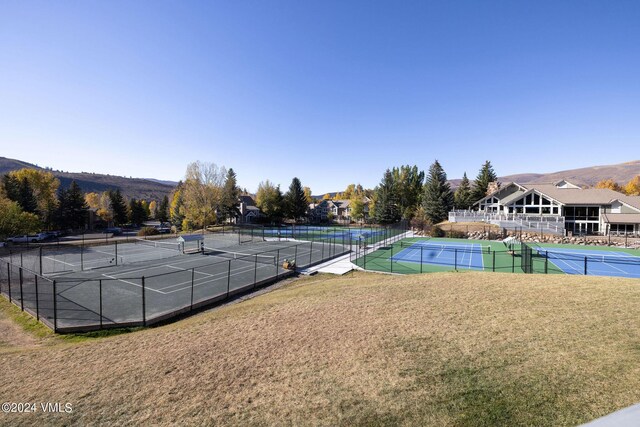 view of tennis court featuring a yard