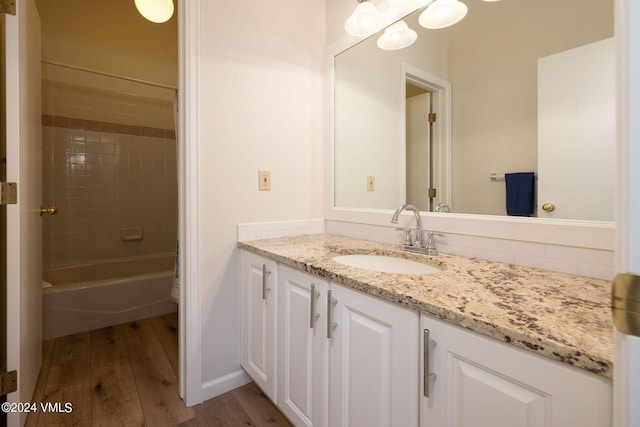 full bathroom featuring vanity, toilet, tiled shower / bath combo, and hardwood / wood-style floors