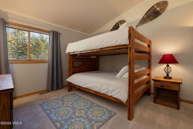 bedroom with lofted ceiling and light carpet