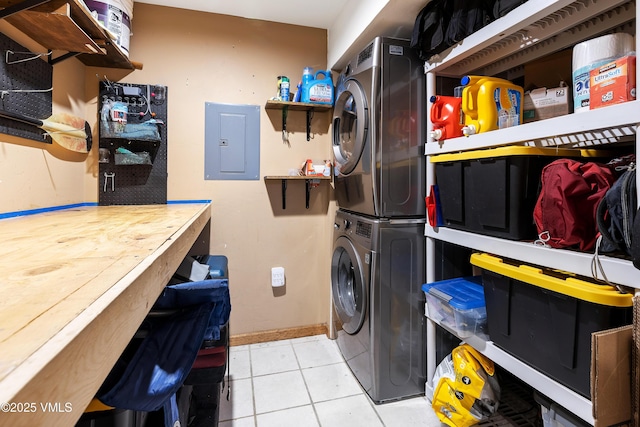 washroom with laundry area, baseboards, stacked washer / drying machine, electric panel, and tile patterned floors