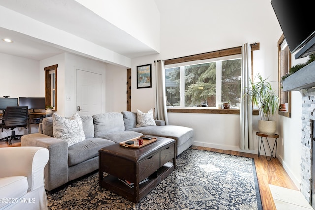 living area featuring baseboards, wood finished floors, and recessed lighting