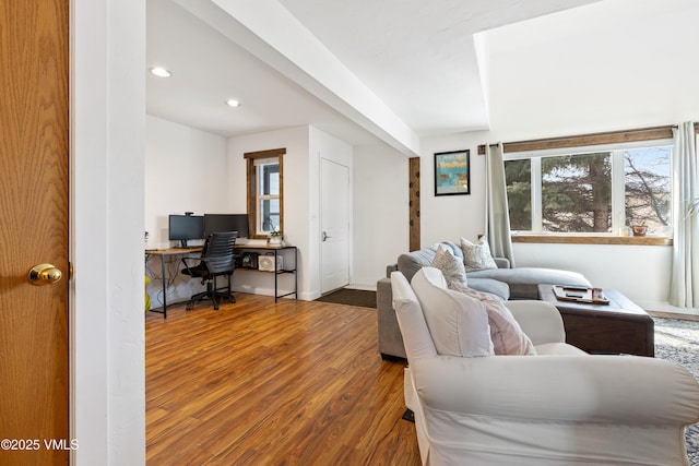 living area with baseboards, wood finished floors, and recessed lighting