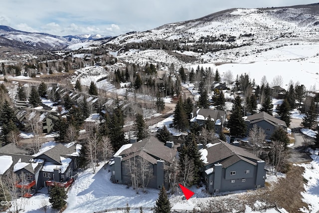 snowy aerial view featuring a residential view and a mountain view