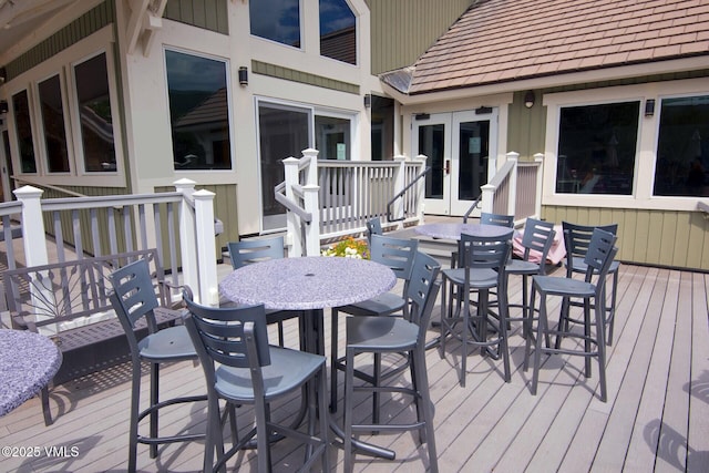 deck with french doors and outdoor dining space