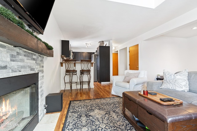 living area featuring a fireplace with flush hearth and light wood-type flooring