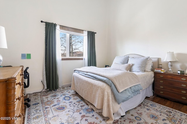 bedroom with baseboards and wood finished floors