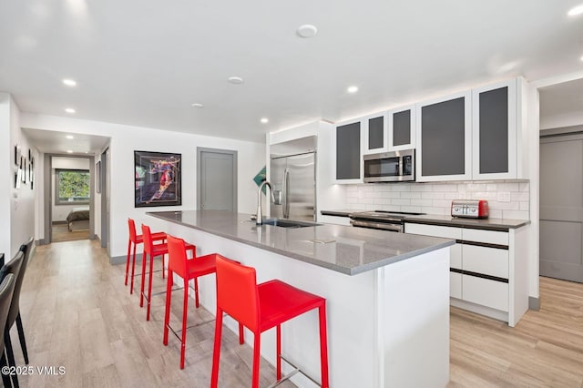 1650 Fallridge Rd Unit 120, Vail, CO 81657 - kitchen featuring stainless steel appliances, light wood finished floors, a breakfast bar, backsplash, and recessed lighting