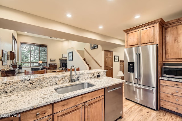 803 June Creek Rd, Edwards, CO 81632 - kitchen featuring appliances with stainless steel finishes, a sink, light stone counters, light wood-style flooring, and recessed lighting