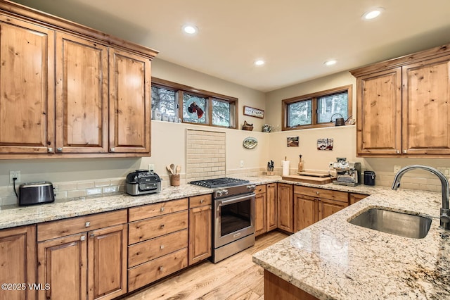 803 June Creek Rd, Edwards, CO 81632 - kitchen featuring stainless steel gas range, a sink, light wood-style floors, recessed lighting, and light stone countertops