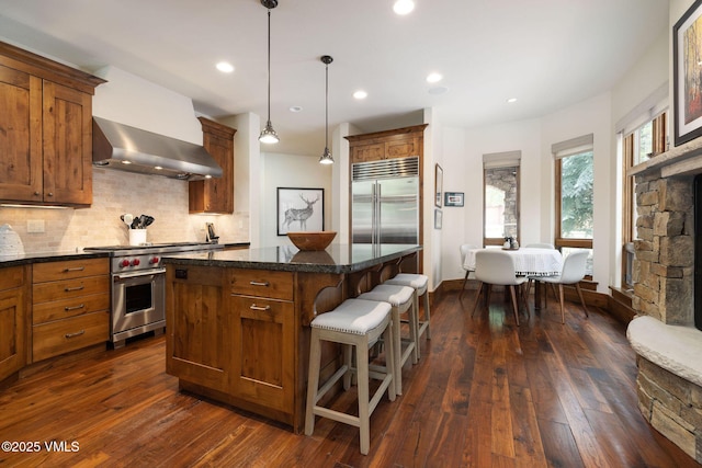 80 Mountain Retreat Ct, Edwards, CO 81632 - kitchen featuring premium appliances, a center island, dark wood-style flooring, a kitchen breakfast bar, and tasteful backsplash