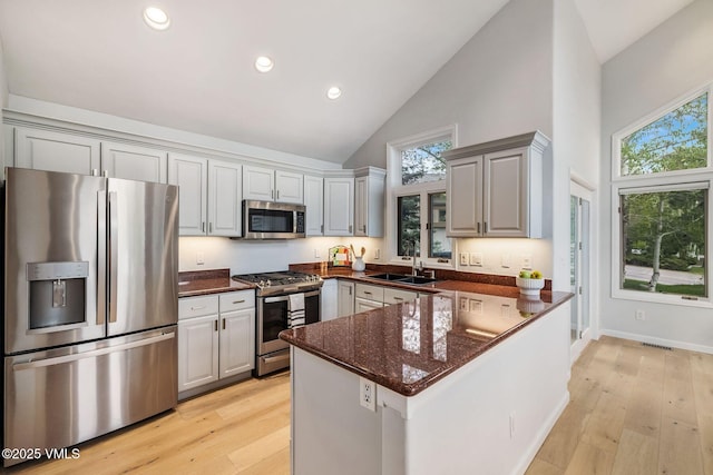 210 June Creek Rd Unit A, Edwards, CO 81632 - kitchen with stainless steel appliances, high vaulted ceiling, a sink, plenty of natural light, and a peninsula