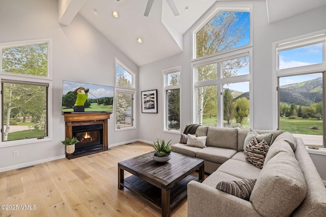210 June Creek Rd Unit A, Edwards, CO 81632 - living area with high vaulted ceiling, light wood-type flooring, a glass covered fireplace, ceiling fan, and baseboards