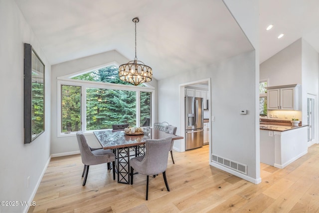210 June Creek Rd Unit A, Edwards, CO 81632 - dining area featuring lofted ceiling, a chandelier, light wood-style floors, and healthy amount of natural light