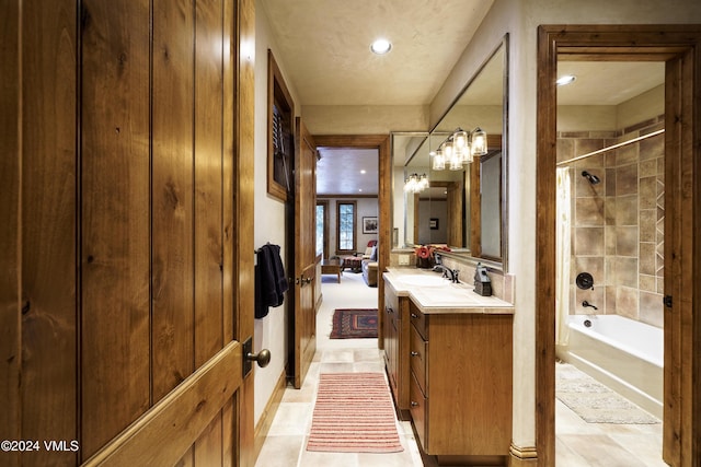 bathroom featuring tiled shower / bath and vanity