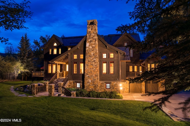 back house at dusk with a yard and a patio area