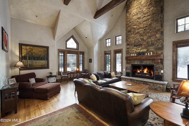 living room featuring hardwood / wood-style floors, beam ceiling, a fireplace, and high vaulted ceiling