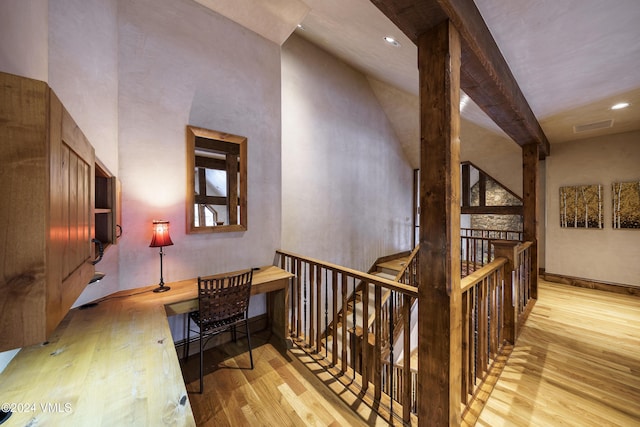 corridor featuring a towering ceiling and light hardwood / wood-style flooring