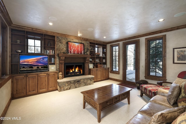 carpeted living room with built in shelves and a stone fireplace