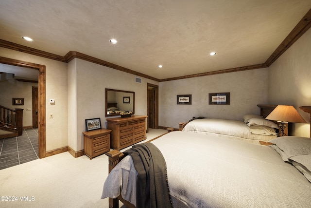 bedroom with ornamental molding and light colored carpet