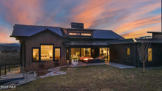 1658 E Haystacker Dr, Eagle, CO 81631 - rear view of house with a standing seam roof, a patio, metal roof, and a yard