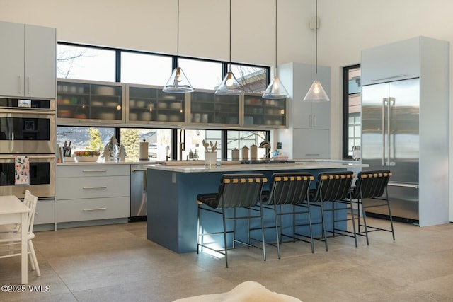 1658 E Haystacker Dr, Eagle, CO 81631 - kitchen featuring appliances with stainless steel finishes, a center island, a towering ceiling, a kitchen breakfast bar, and pendant lighting