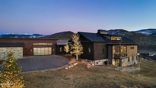 1658 E Haystacker Dr, Eagle, CO 81631 - view of front facade with driveway, a mountain view, an attached garage, and metal roof