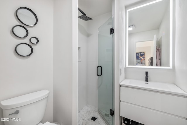 bathroom with vanity, a shower with door, and toilet